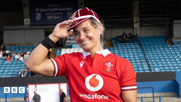 Kerin Lake smiling while wearing her 50th cap