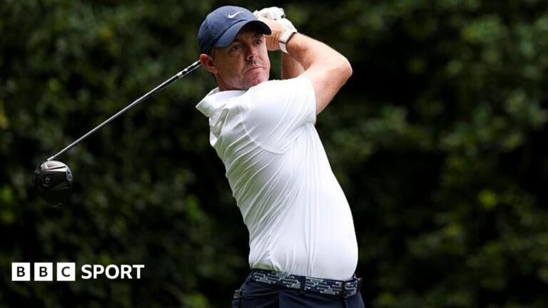 Rory McIlroy cards 70 in first round at Quail Hollow in Truist Championship Rory McIlroy at the Truist Championship, wearing a white golf shirt and blue cap, swinging a metal wood