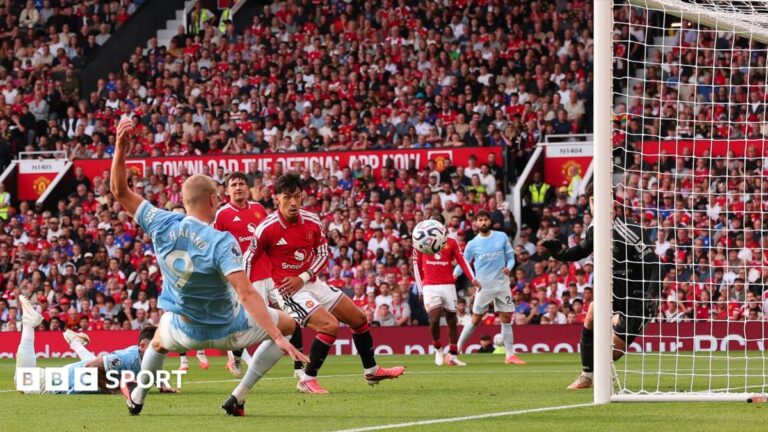 Erling Haaland of Manchester City speaks with referee Michael Oliver as a VAR check is performed after his goal is initially ruled offside